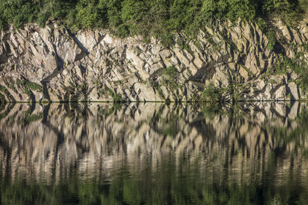 Photo of the reflections of a cliff in water. の写真素材