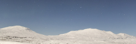 Abstract photo of the tops of mountains covered in snow taken at night.の写真素材