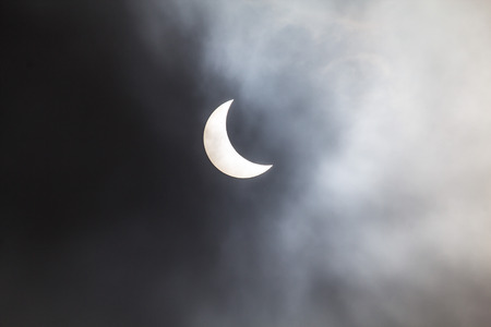 Photo through the clouds of the solar eclipse from Cambridgeshire in the UKの写真素材