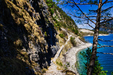 Small path along a mountain by a lakeの写真素材