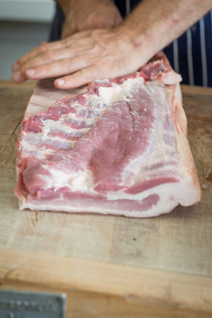 Friendly man preparing raw meat at the butchersの写真素材