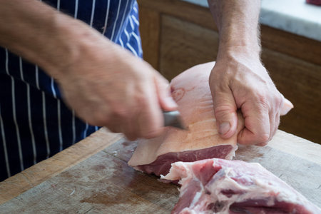 Friendly man preparing raw meat at the butchersの写真素材