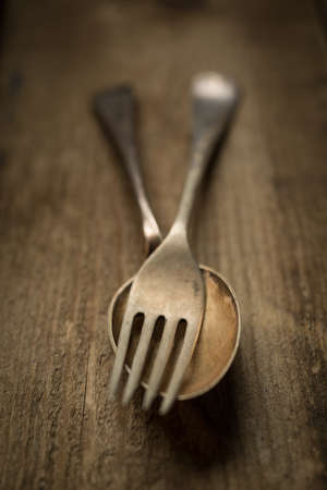 Vintage rustic cutlery,fork,spoon, on wooden panelling background.の写真素材
