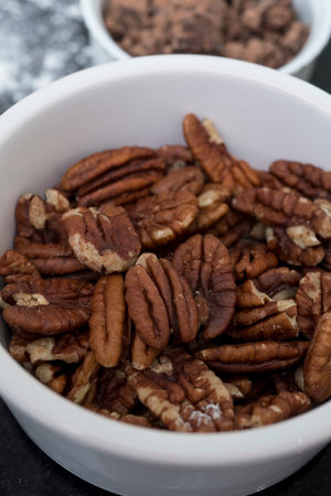A close up shot of a ramekin containing pecan nuts