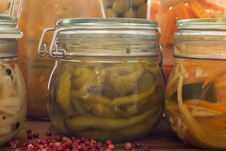 A close up selection of pickled and fermented vegetables in Kilner jars