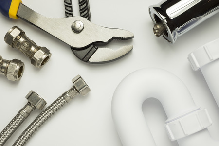 A selection of plumbing tools and fittings on a white backgroundの写真素材