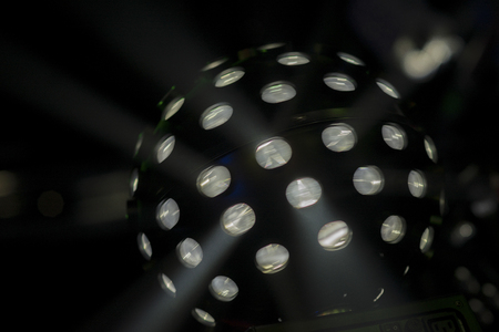 Bright coloured moving white disco lightball shot in darkened nightclub  settingの写真素材