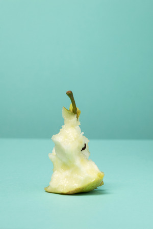 A single apple core on a blue green backdropの写真素材