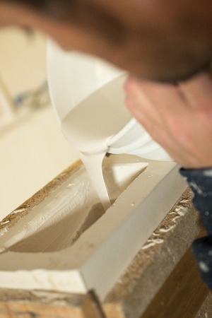 Closeup of liquid plaster being poured into mold.の写真素材