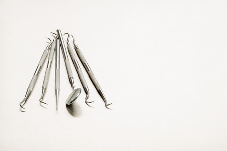 Selection of dentists tools on a stainless steel background with space for text or copyの写真素材