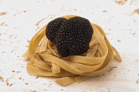 Black truffle sitting on a tagliatelle nestの写真素材