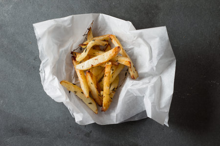 Cooked chips on a crumpled paper on a gray background
