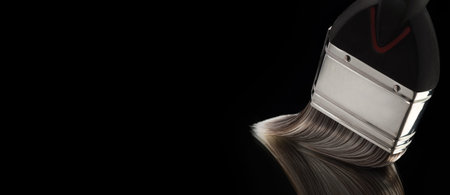 Paint brush with its bristles gliding on a smooth reflective surface