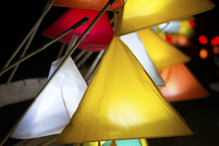 Pyramid-shaped illuminated paper lanterns in a dark eveningの写真素材