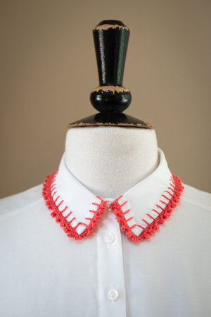 White shirt collar with red knitted or crocheted edges