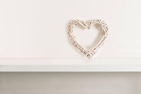 Wicker heart on white shelvingの写真素材