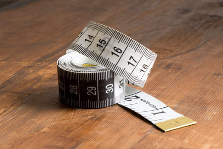 A roll of tape measure on a wooden tabletop