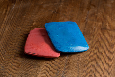 Red and blue tailor's chalk on a wooden tabletopの写真素材