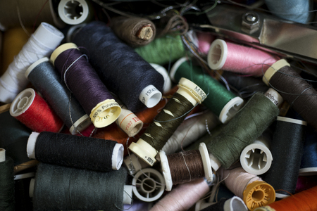 A pile of spools of thread of various colors for backgroundsの写真素材