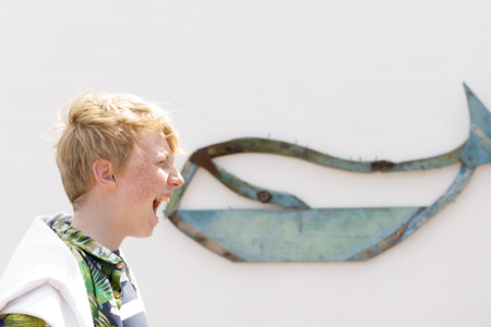 Forced-perspective photo of boy eating whale logoの写真素材