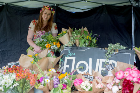 Girl selling bouquets of flowers in her outdoor stall