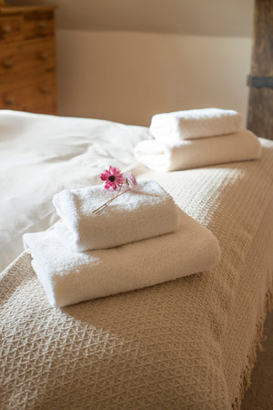 Two stacks of folded towels placed in a bedの写真素材