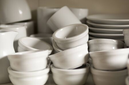 Stacks of clean and empty dipping bowls or ramekin with other dishware in the backgroundの写真素材