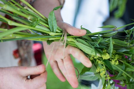 Hands tying a string to a bunch of flowersの写真素材