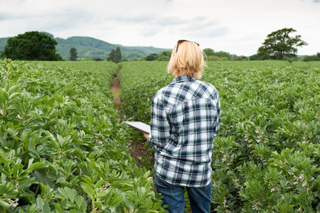Lady clutching a tablet computer and looking over a plantation