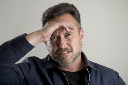 Bearded man with hand on forehead looking stressed, headacheの写真素材
