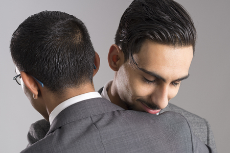 Closeup of two businessmen embracing each otherの写真素材