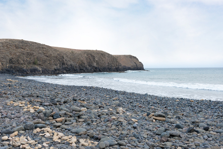 Beach view with low cliffs and a calm sea looking towards Papagajoの写真素材