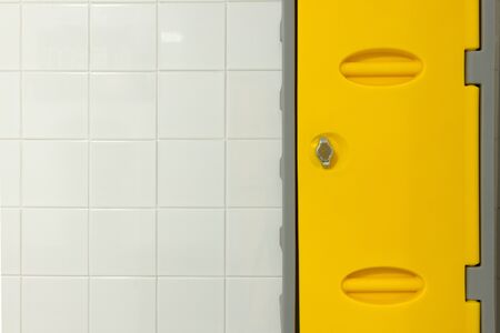 White tiled wall and yellow locker doorの写真素材