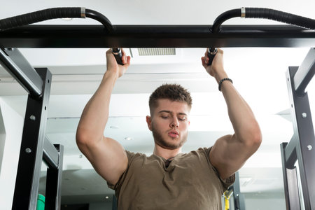 Young man doing parallel grip bicep pull up in gym