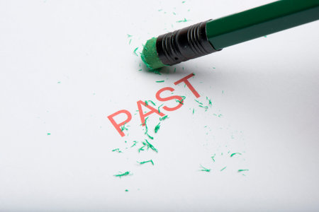 The word 'past' on paper with worn pencil eraser and eraser shavings. Concept of forgetting or...