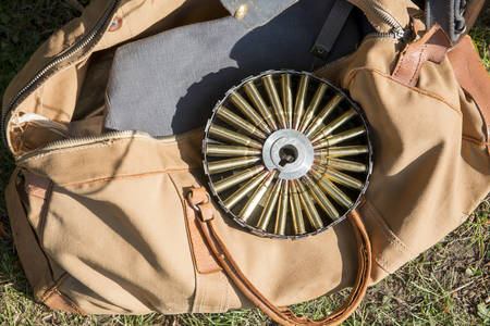 Rifle ammunition in a round case laid on an old tote bagの写真素材