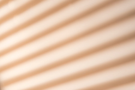 Defocused wall with shadow of window blinds for backgrounds