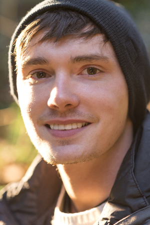 Close Up portrait of a young man wearing bonnet and jacket outdoorsの写真素材
