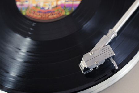 Overhead view of a record player tone arm on a spinning vinyl discの写真素材