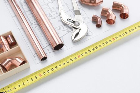 Vice grip and copper pipes on draft with tape measure running across imageの写真素材