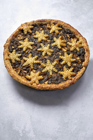 Large whole mince pie and a spoon, traditional British Christmas food with copy spaceの写真素材