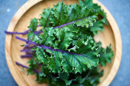 Focused closeup shot of red russian kale leaves on wooden plate