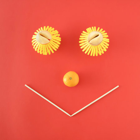 Chinese festive happy face. Abstract concept made from fortune cookies, paper-crafted lanterns and mandarin. Minimal flat layout on pastel red background.の写真素材