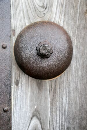 Iron knob on an ancient wooden doorの写真素材