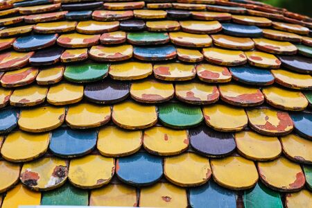 Colorful worn out round tiles with yellow green and blue colors.の写真素材