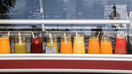 Juice fruit stand with various colorful juicesの写真素材