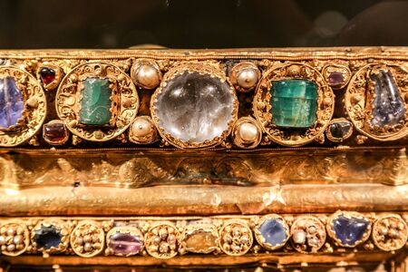 Antique gold jewelry with green and transparent stones.の写真素材