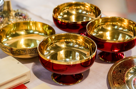 Gold and red bowls at a mass in church.の写真素材