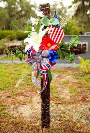 Confederate ribbon on a wooden cross with flowers at a cemetary.の写真素材