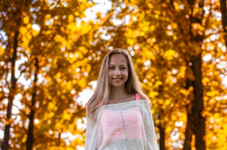 Beautiful young happy woman in autumn park の写真素材